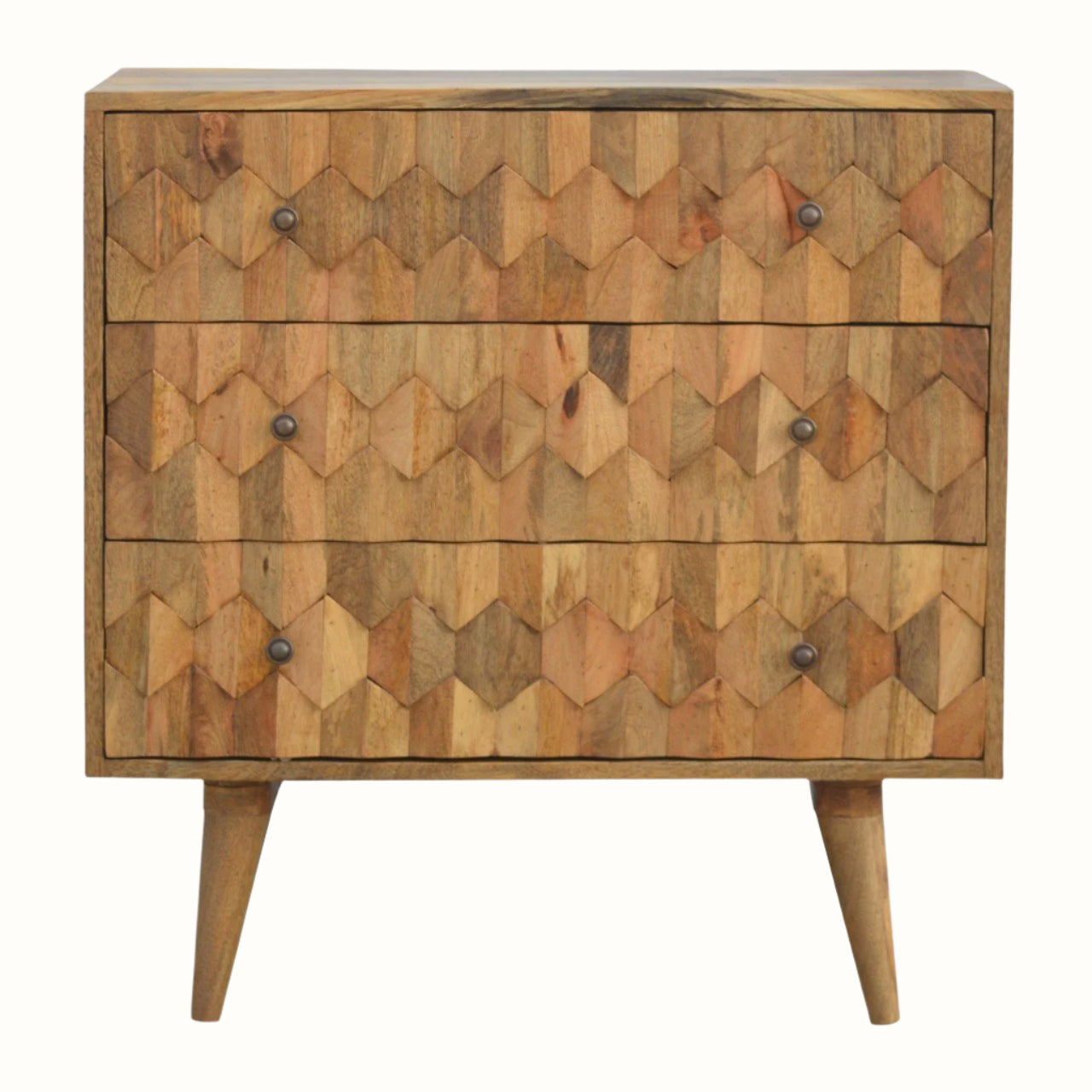 A medium-sized chest of drawers with a natural finish, featuring a hand-carved pineapple pattern on the front and brass knobs. It is on four short Nordic-style legs.