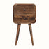 A small bedside table with four legs, made of mango wood with a grey wash finish, featuring two drawers with brass knobs.