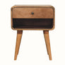A natural finish mango wood bedside table with an open slot shelf, a drawer, and a brass knob on a white background.