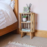 Bedroom featuring a natural finish mango wood bedside table with a slatted design and two open shelves.
