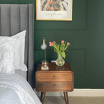 A stylish green bedroom featuring a curved nightstand in a dark brown mango wood stain.