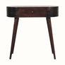 A curved console table with a light walnut finish, featuring a drawer with a brass knob and tapered legs.