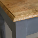 Close-up of a wooden table edge with a blurred background