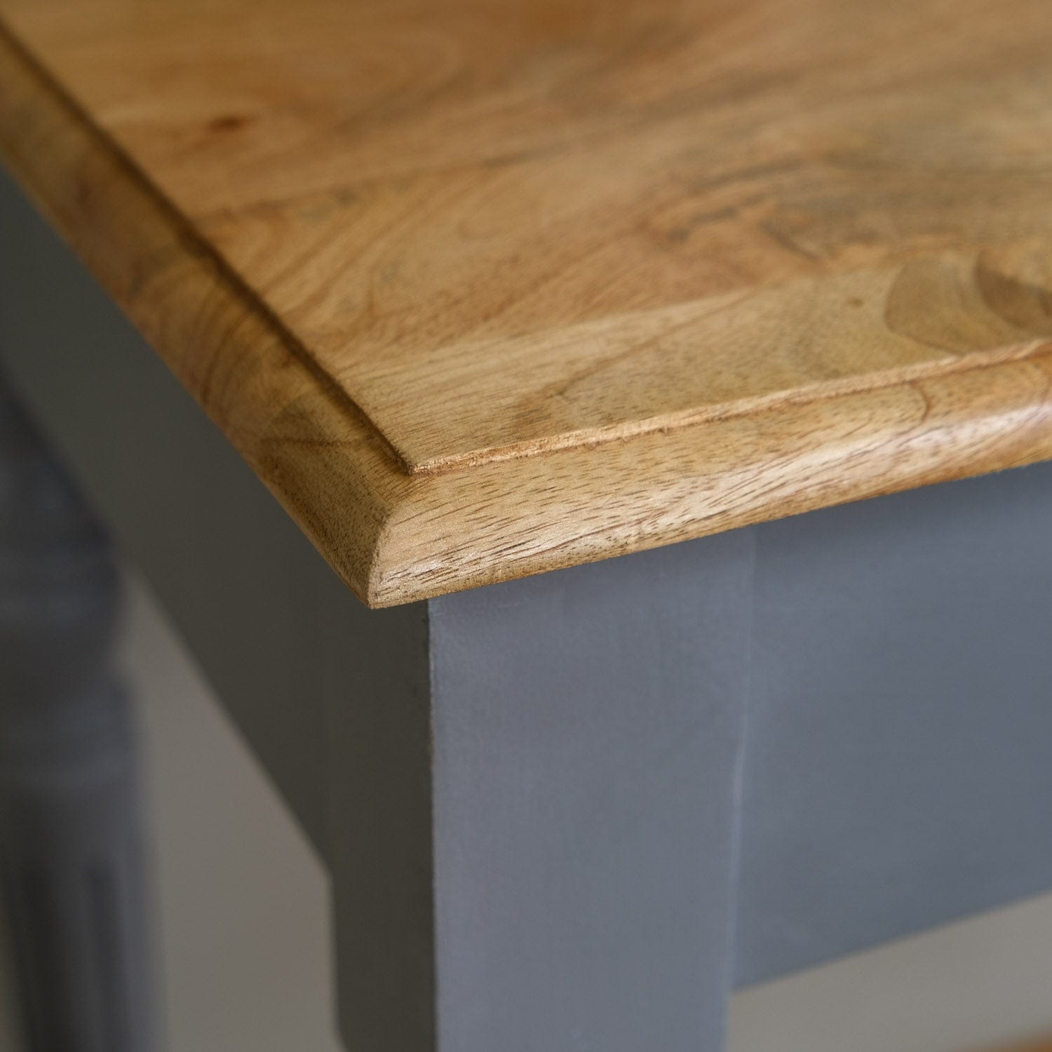 Close-up of a wooden table edge with a blurred background
