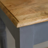 Close-up of a wooden table edge with a blurred background