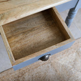 Wooden drawer with a metal handle on a piece of furniture.